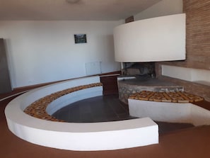 Relax in this stylish room with a curved bench, fireplace, and high ceiling.
