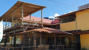 Un bâtiment à deux étages doté d’un balcon en bois et d’un patio couvert.