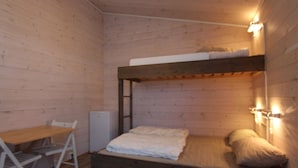 A bunk bed with a wooden frame and a desk with a chair beside it. - Trolltunga Camping (Ullensvang)