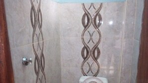 Une petite salle de bain avec des toilettes, une poubelle rouge et un bidet.