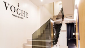 Un escalier avec des rampes en verre menant à un palier.