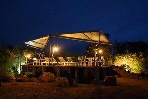 Ein überdachter Außenbereich mit Lounge-Möbeln und einer Markise.