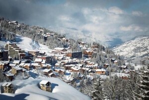 Un pueblo cubierto de nieve con edificios y árboles.