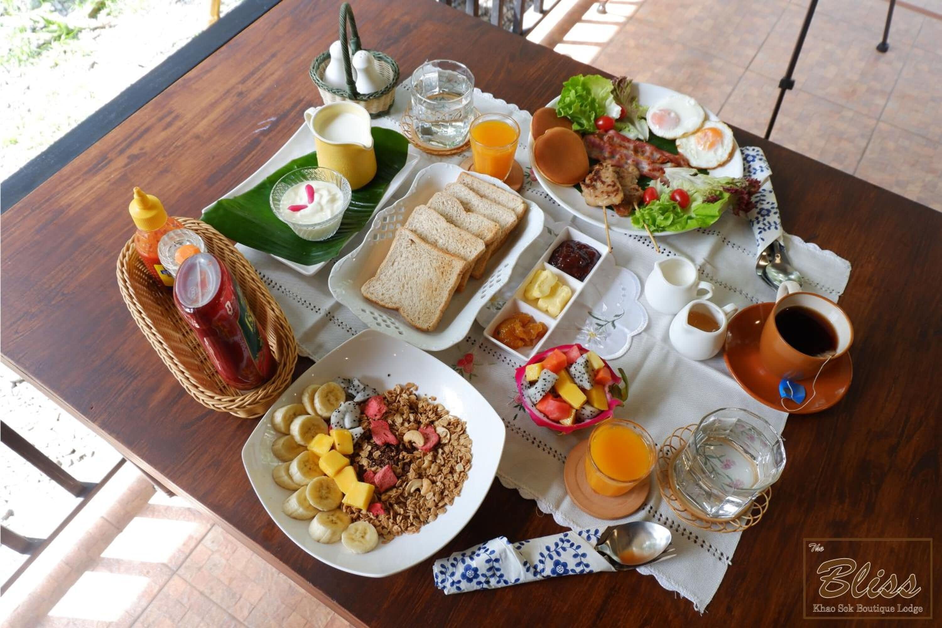 A breakfast buffet with various dishes, including pancakes, eggs, and a fruit bowl.