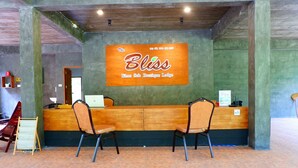 Een receptiebalie met een bord waarop staat: The Bliss Khao Sok Boutique Lodge.
