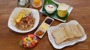 Een ontbijttafel met diverse producten, zoals cornflakes, toast en fruit.