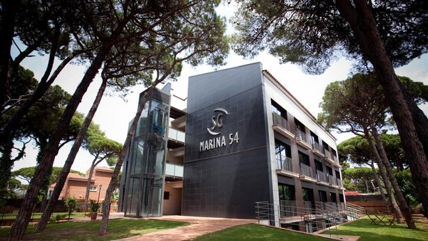 A modern building with a sign reading "MARINA 54". - SG Marina 54 Apartments (Castelldefels)