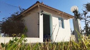 Un petit bâtiment d’un seul étage, doté d’un toit recouvert de tuiles et d’une antenne parabolique.