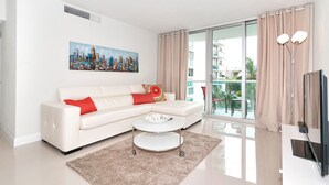 Ein modernes Wohnzimmer mit einem weißen Sofa, einem runden Couchtisch und einem Stadtbild an der Wand.
