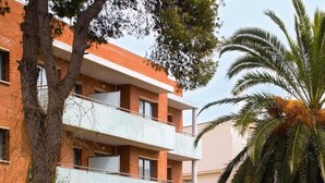 A multi-story building with a swimming pool, outdoor seating, and palm trees. - SG Costa BCN Apartments (Castelldefels)