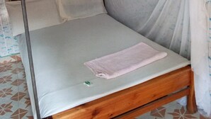 A single bed with a wooden frame, white bedding, and a blue canopy. - Serengeti Gardens Hotel (Nairobi)