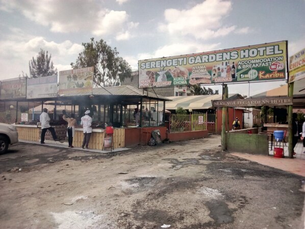 A roadside eatery with a signboard advertising ready pork, goat meat, and other local dishes.
