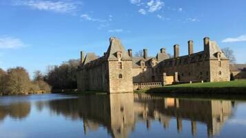 A historic castle with a moat, reflecting its architecture.