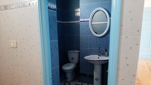 Un baño con inodoro, lavabo y espejo.