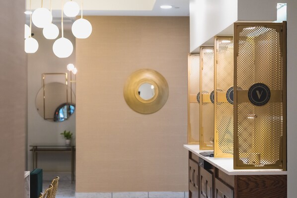 Een moderne badkamer met een spiegel, een ronde wandversiering en een aantal kasten met een decoratief paneel.