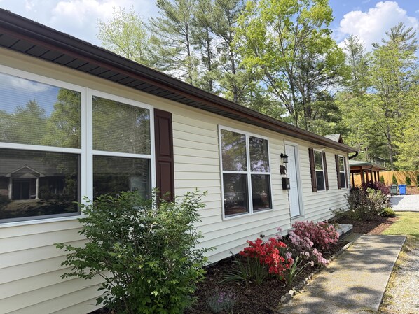 A single-story house with a front porch, large windows, and a mailbox.