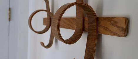 A wooden wall-mounted coat rack with a simple, functional design.