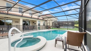 A covered outdoor swimming pool with a hot tub, seating area, and a view of a residential building. - Impressive Waterfront Retreat Near Disney With Cinema Room - 5bd/4ba PH - Rav5341 (Davenport)