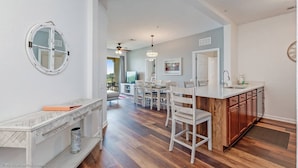 A spacious kitchen with a wooden island, white cabinetry, and a round mirror on the wall. - Stylish and Contemporary Vista Cay Hideaway - Lake View 3bd/2ba #3vc4126 (Orlando)