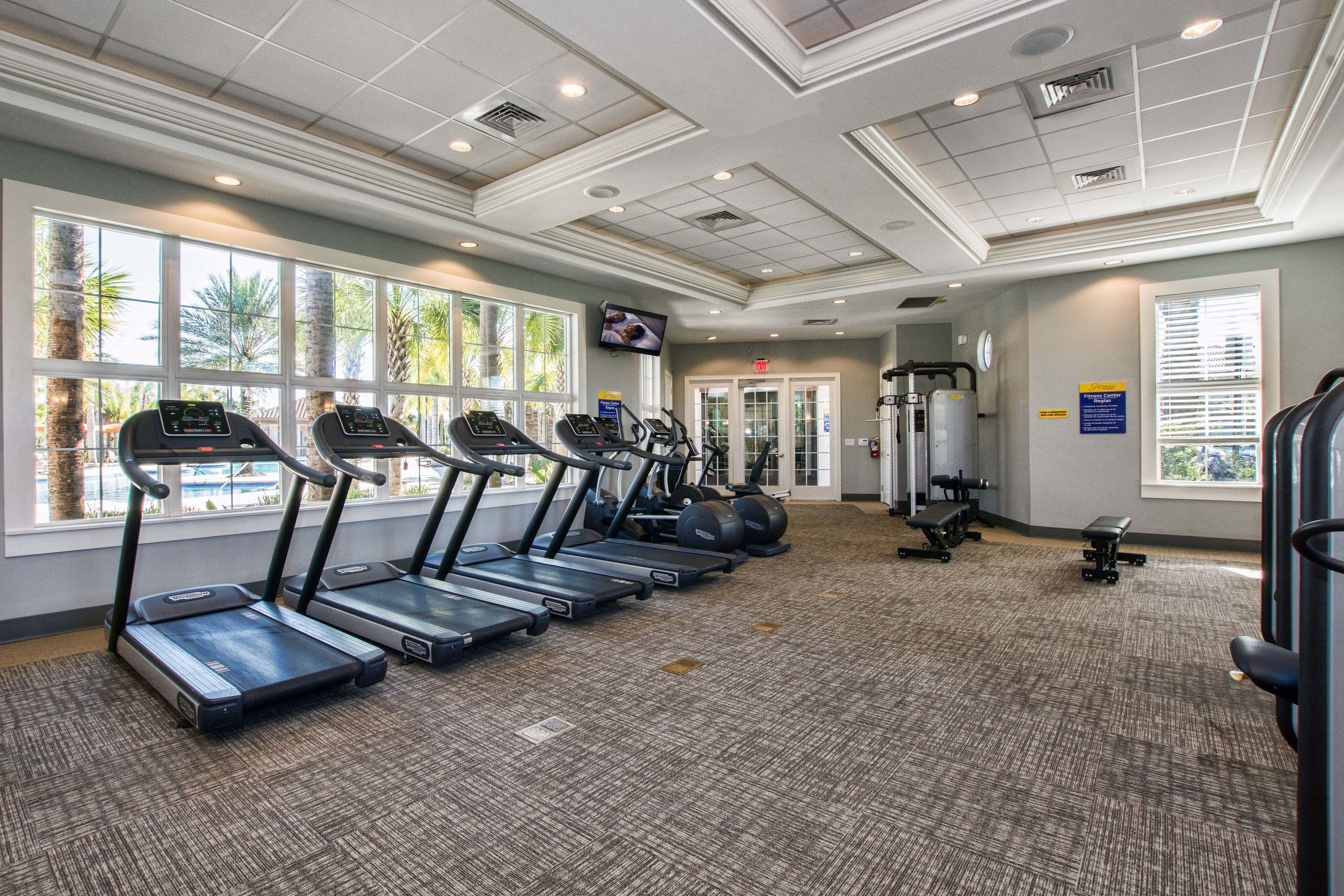 A gym with treadmills, exercise balls, and weight machines.