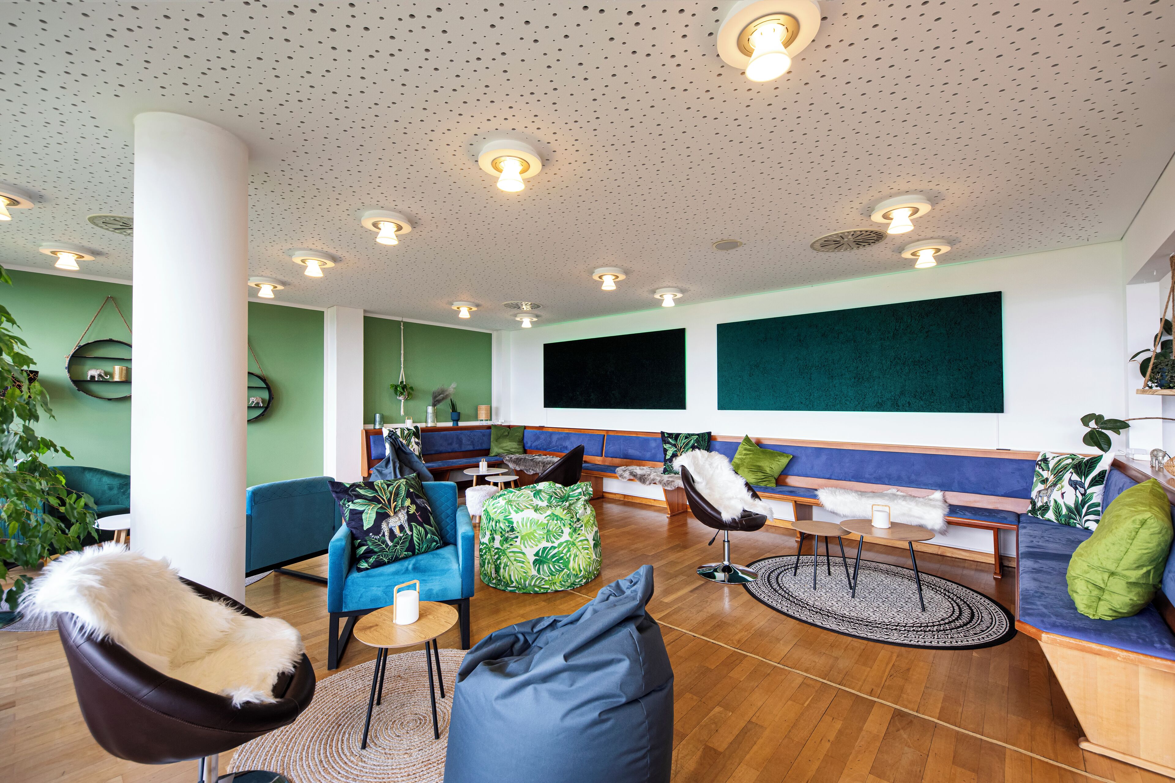 A modern lounge area with seating, a coffee table, and a large plant.