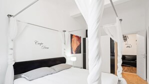 Ein modernes Schlafzimmer mit einem Himmelbett, einem Nachttisch und einer Wandlampe.