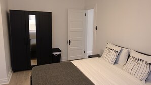 Un dormitorio con cama, armario y puerta.