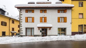 Un edificio de varios pisos con techo nevado y entrada a nivel de calle.