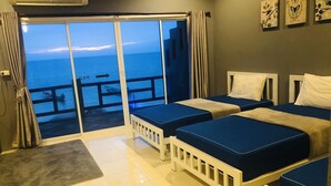 A hotel room with two beds, a view of the sea, and a sliding door leading to a balcony. - Koh Tao My Hostel (Koh Tao)