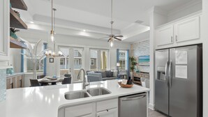 Eine moderne Küche mit einer zentralen Kochinsel, Edelstahlgeräten und einem Deckenventilator.