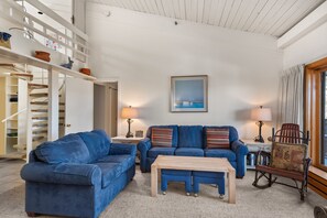 Relax in this inviting living room with a sofa, coffee table, and rocking chair.