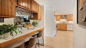 A modern kitchen with wooden cabinets, a marble countertop, and a built-in oven. - On the Slopes, Recent Upgrades, Stonebridge Condo #935, Steps to Base Village (Snowmass Village)