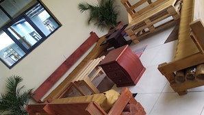 Una habitación con un gran ventanal, un cuadro en la pared y varios muebles de madera.