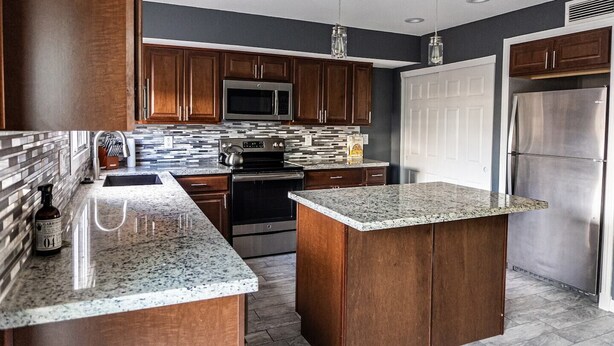A modern kitchen with dark wood cabinets, stainless steel appliances, and a granite countertop. - Old Town Scottsdale hidden gem! Hot Tub is private! Inquire pricing! (Scottsdale)