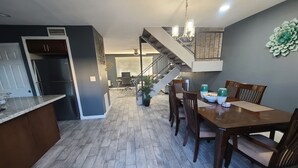 A modern kitchen with a built-in refrigerator, a dining area with wooden chairs, and a staircase leading to an upper level. - Old Town Scottsdale hidden gem! Hot Tub is private! Inquire pricing! (Scottsdale)