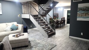 A modern living room with a staircase, a dining area, and a kitchen in the background. - Old Town Scottsdale hidden gem! Hot Tub is private! Inquire pricing! (Scottsdale)