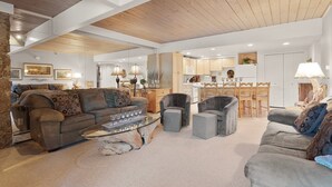 A spacious living room with a high ceiling, a dining area, and a kitchen. - 1BR condo Base Village with pool, hot tub, 700 Stonebridge Condos (Snowmass Village)