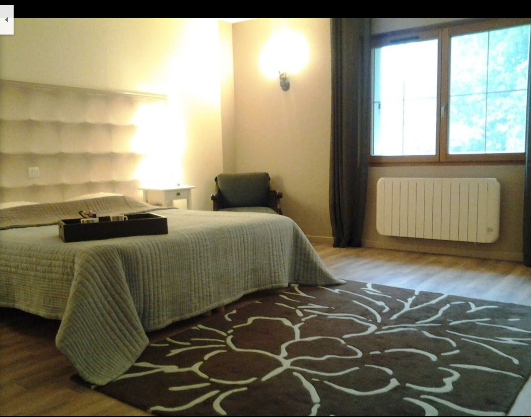Une chambre avec deux lits, un radiateur et une fenêtre avec des rideaux.