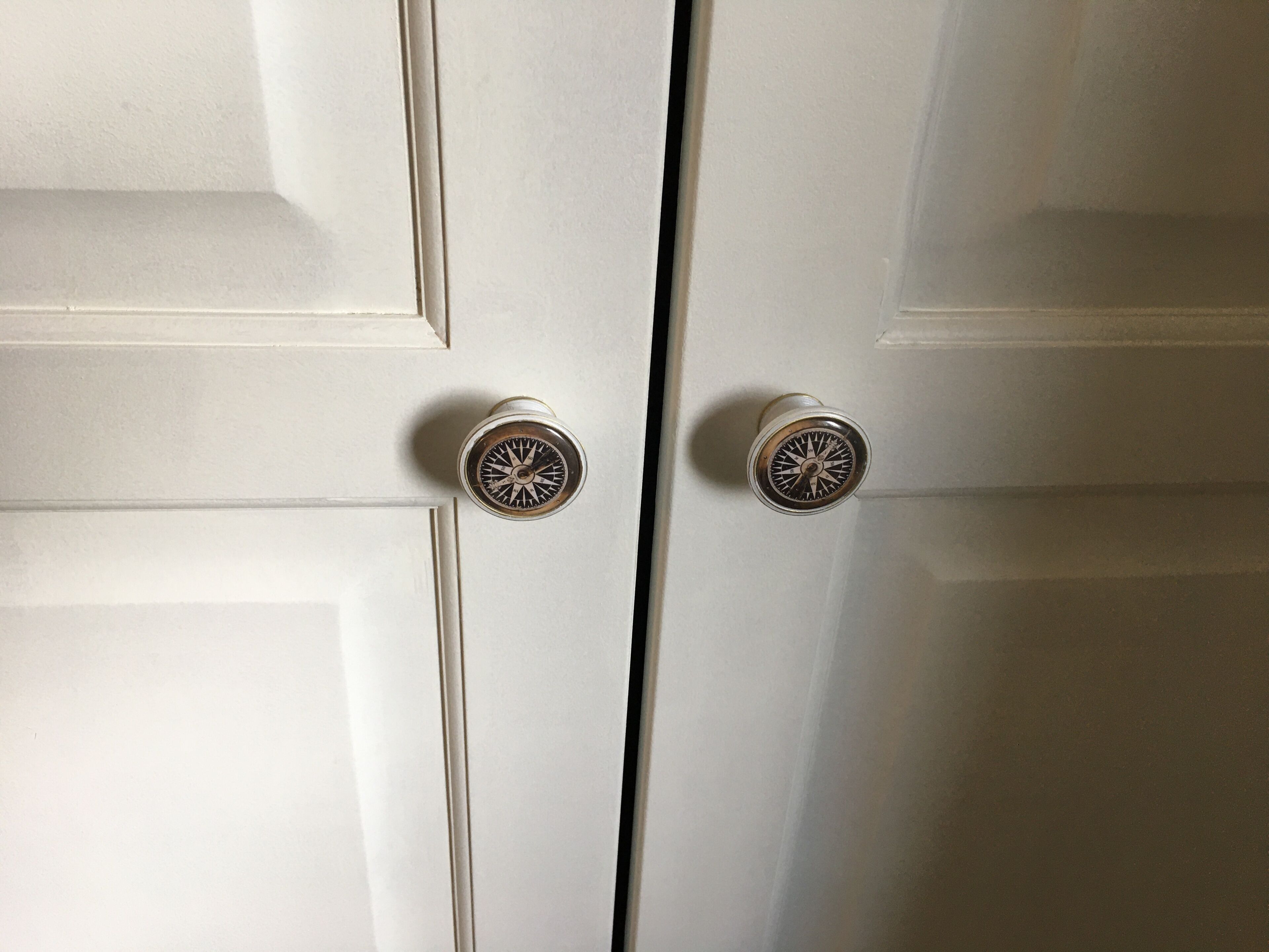 Une porte blanche avec deux poignées de porte rondes et métalliques.