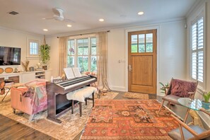 A living room with a piano, a glass coffee table, and a patterned rug. - Pool & Hot Tub: Ideally Located 'Austin Oasis' (Austin)