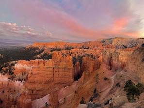 A canyon landscape with layered rock formations and sparse vegetation.