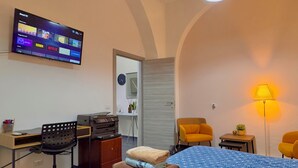 A hotel room with a bed, desk, chair, and a TV displaying a streaming service interface. - A. M.P. Vatican House (Roma)