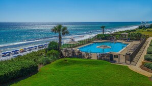 A pool area with a view of the beach and ocean.