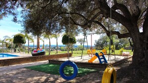 A playground with a swing set, tire swings, and a slide. - Beautiful Restored Algarve Typical Farmhouse, With Private Pool And Sea Views (Loulé)
