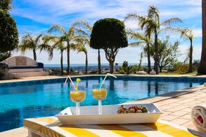 A poolside setting with a tray of two drinks and a bowl of fruit. - Beautiful Restored Algarve Typical Farmhouse, With Private Pool And Sea Views (Loulé)
