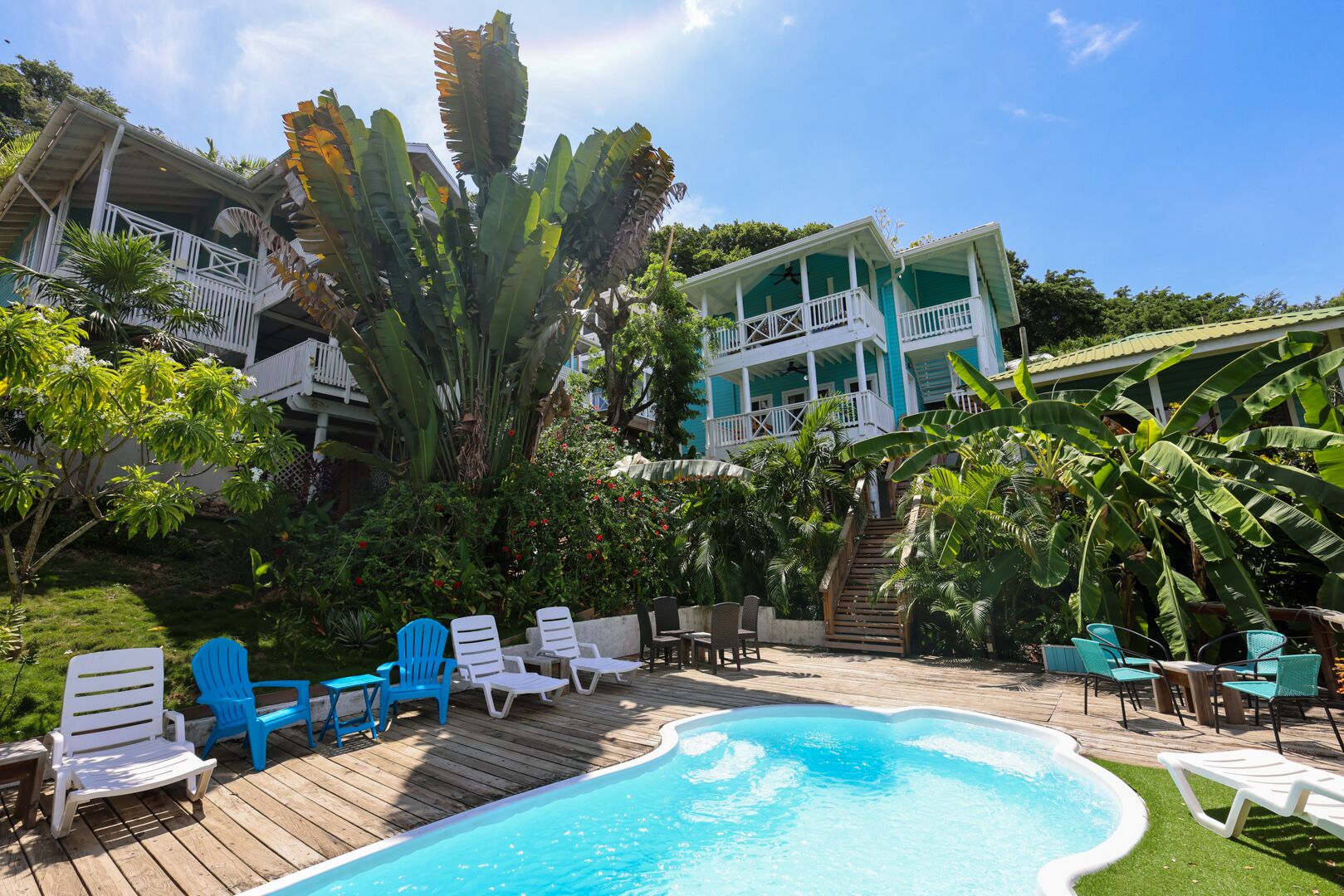 A pool area with lounge chairs and a wooden deck.