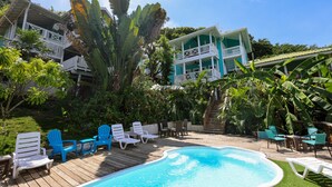 A pool area with lounge chairs and a wooden deck.