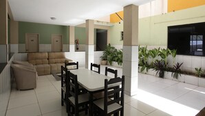 Un coin repas avec une table et des chaises, un canapé et des plantes en pot.