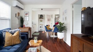 Un salon moderne avec un canapé bleu, une table basse et un meuble pour la télévision.
