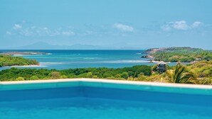 A pool with a view of a tropical beach and a small island. - Villa entre Ciel et Mer (Sainte-Anne)